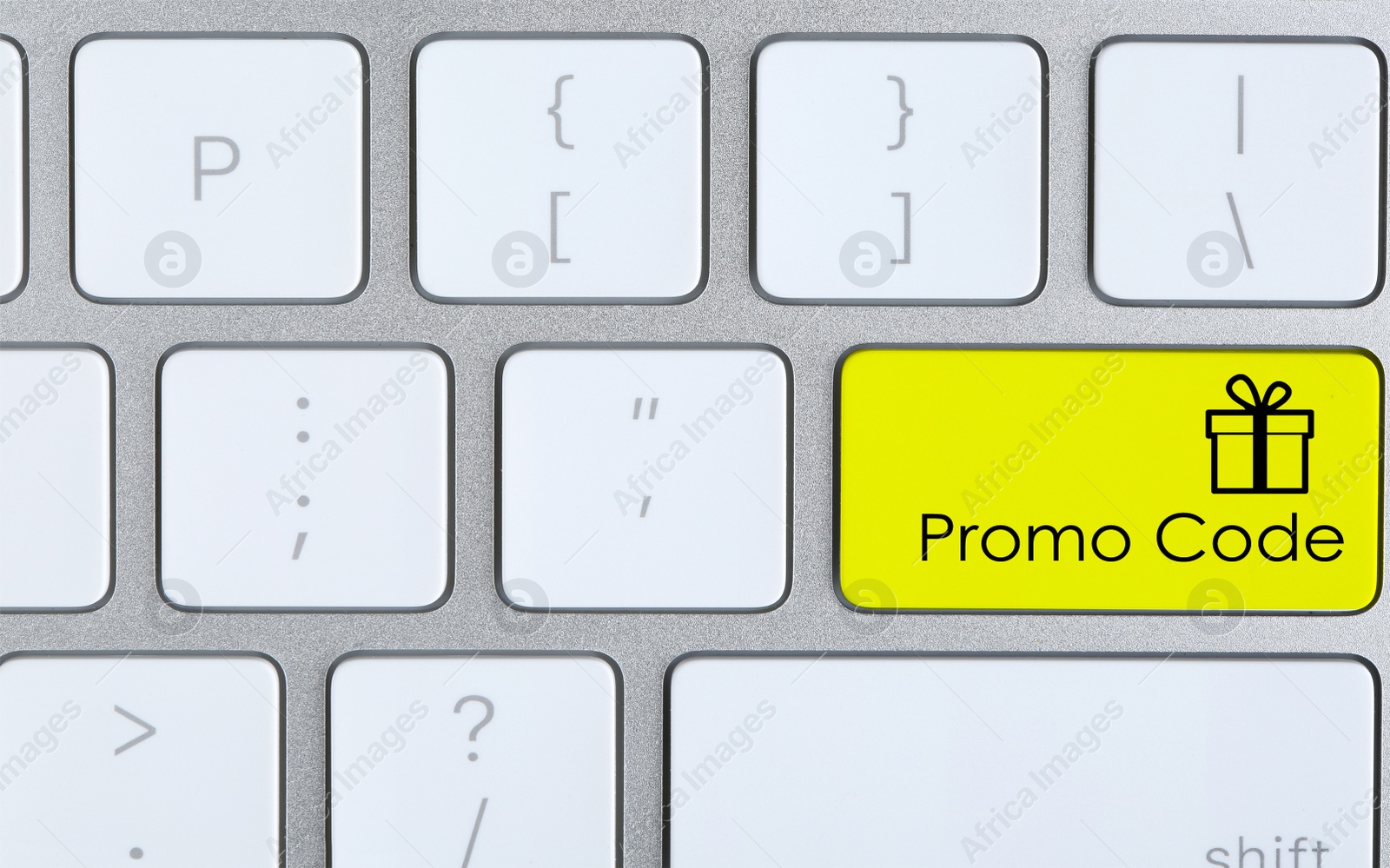 Image of Yellow button with phrase Promo Code and image of gift box on computer keyboard, top view