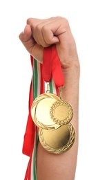 Man holding golden medals on white background, closeup. Space for design