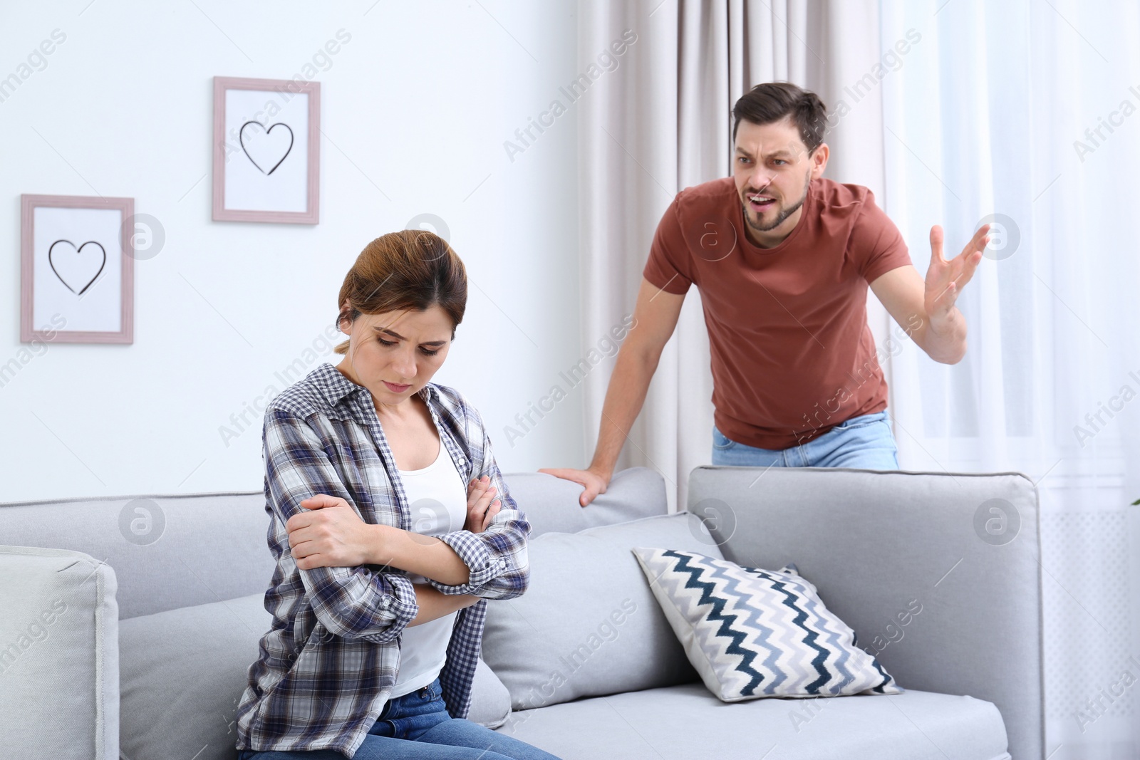 Photo of Couple arguing in living room. Relationship problems