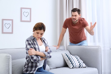 Photo of Couple arguing in living room. Relationship problems