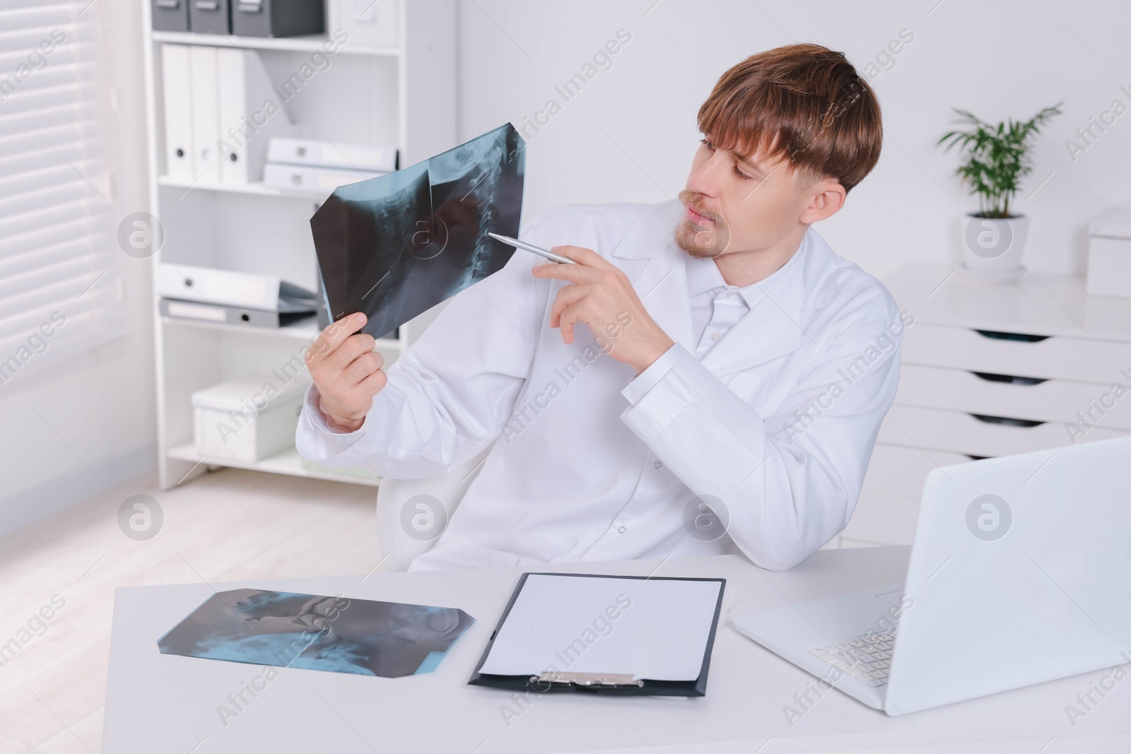 Photo of Doctor examining neck MRI image in clinic