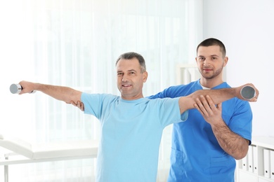 Doctor working with patient in hospital. Rehabilitation exercises