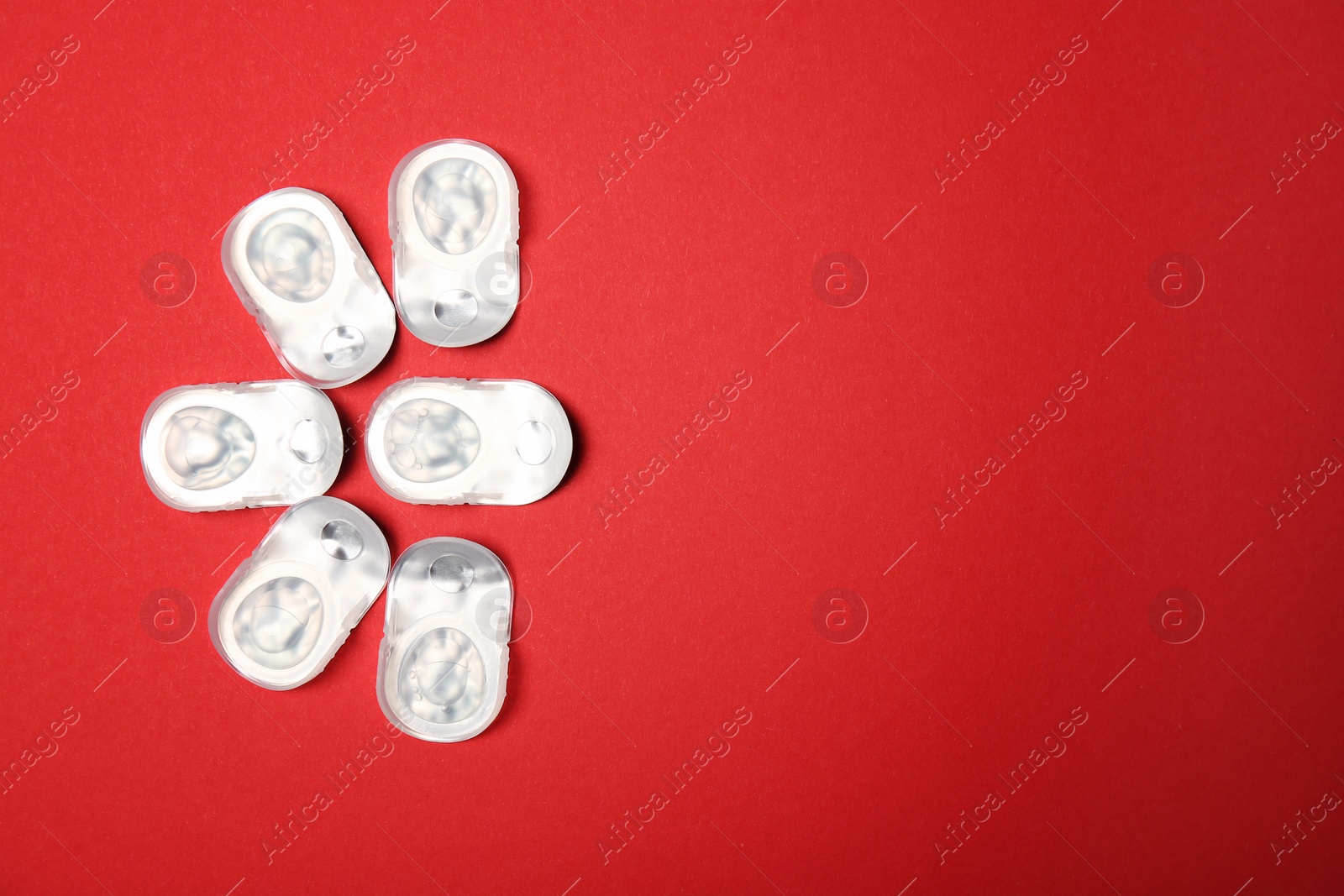 Photo of Flat lay composition with contact lenses in packages on color background