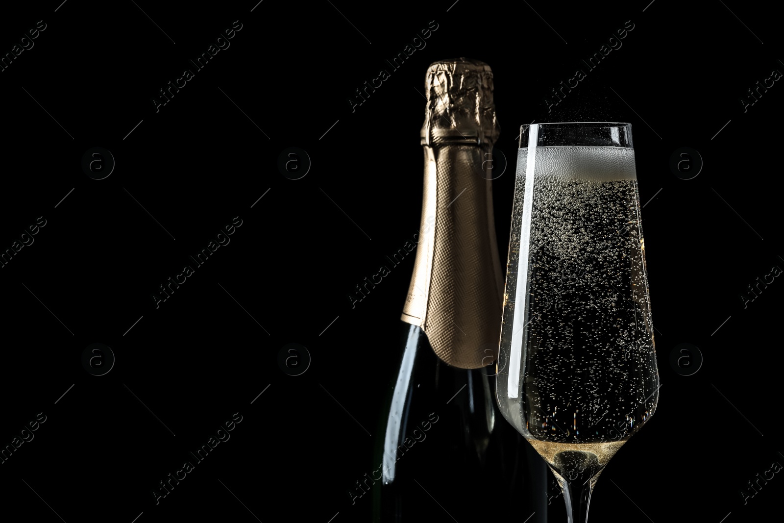 Photo of Bottle and glass of champagne on black background, space for text