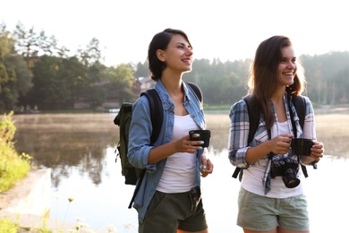 Young friends on shore of beautiful lake. Camping season