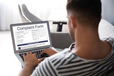 Man filling online complaint form via laptop at home