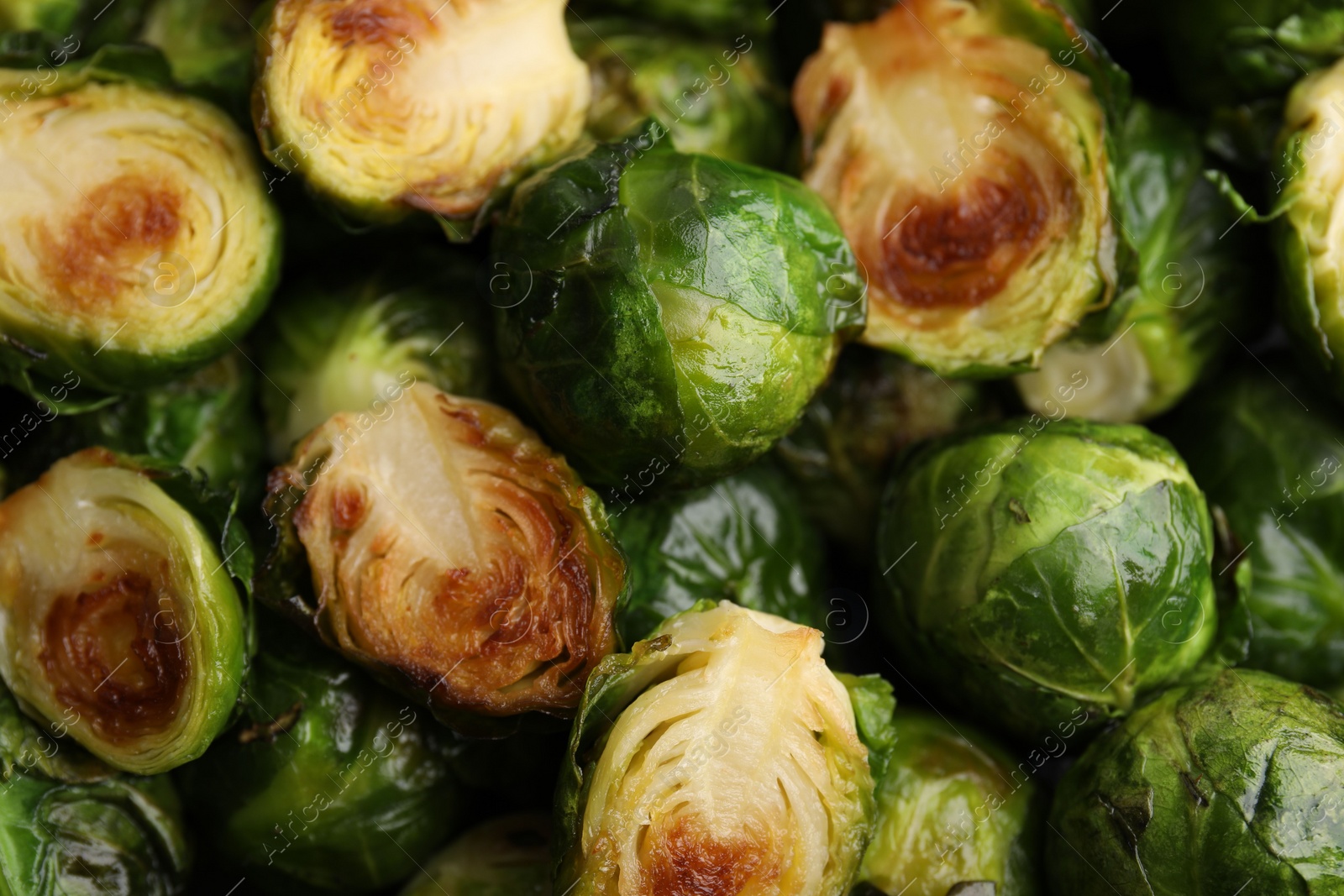 Photo of Delicious roasted Brussels sprouts as background, closeup