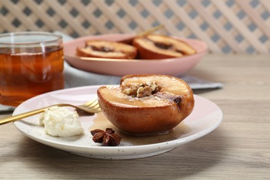 Photo of Delicious quince baked with honey and walnuts on wooden table
