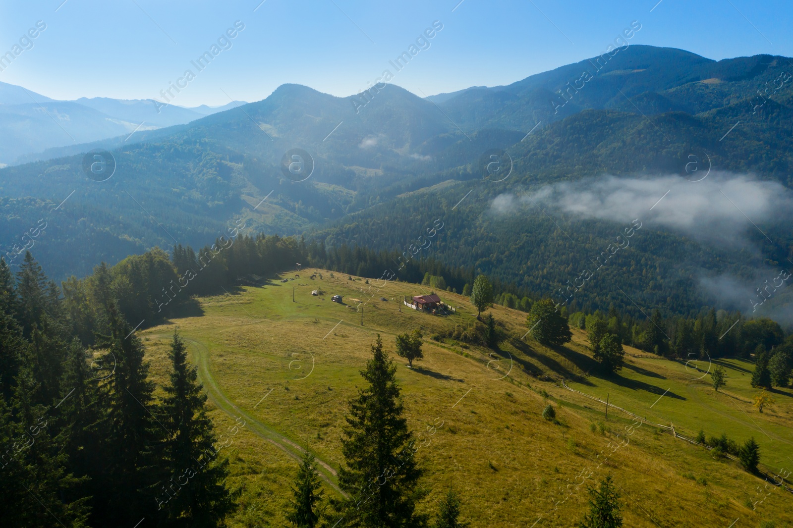 Image of Aerial view of beautiful landscape with misty forest and village in mountains