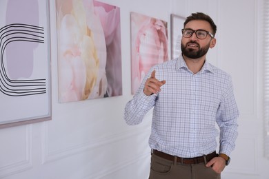 Young man at exhibition in art gallery