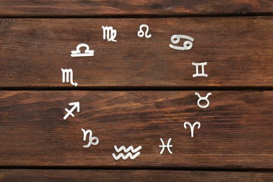 Photo of Zodiac signs on wooden background, flat lay. Space for text