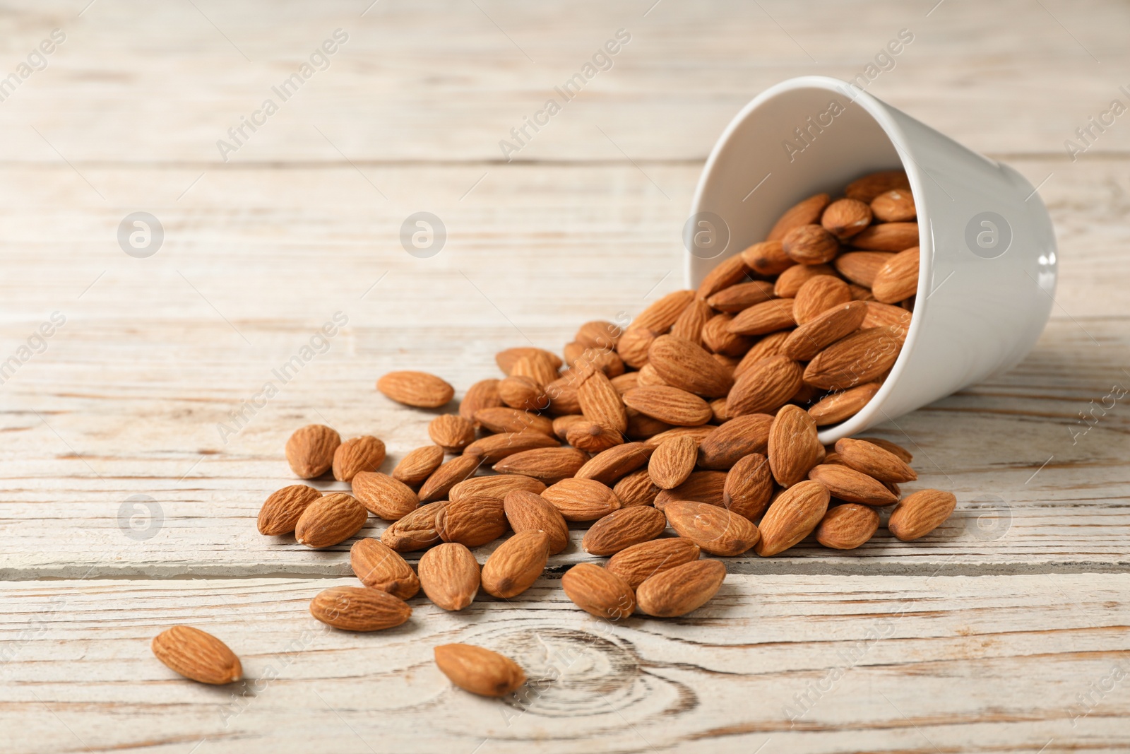 Photo of Tasty organic almond nuts and bowl on table