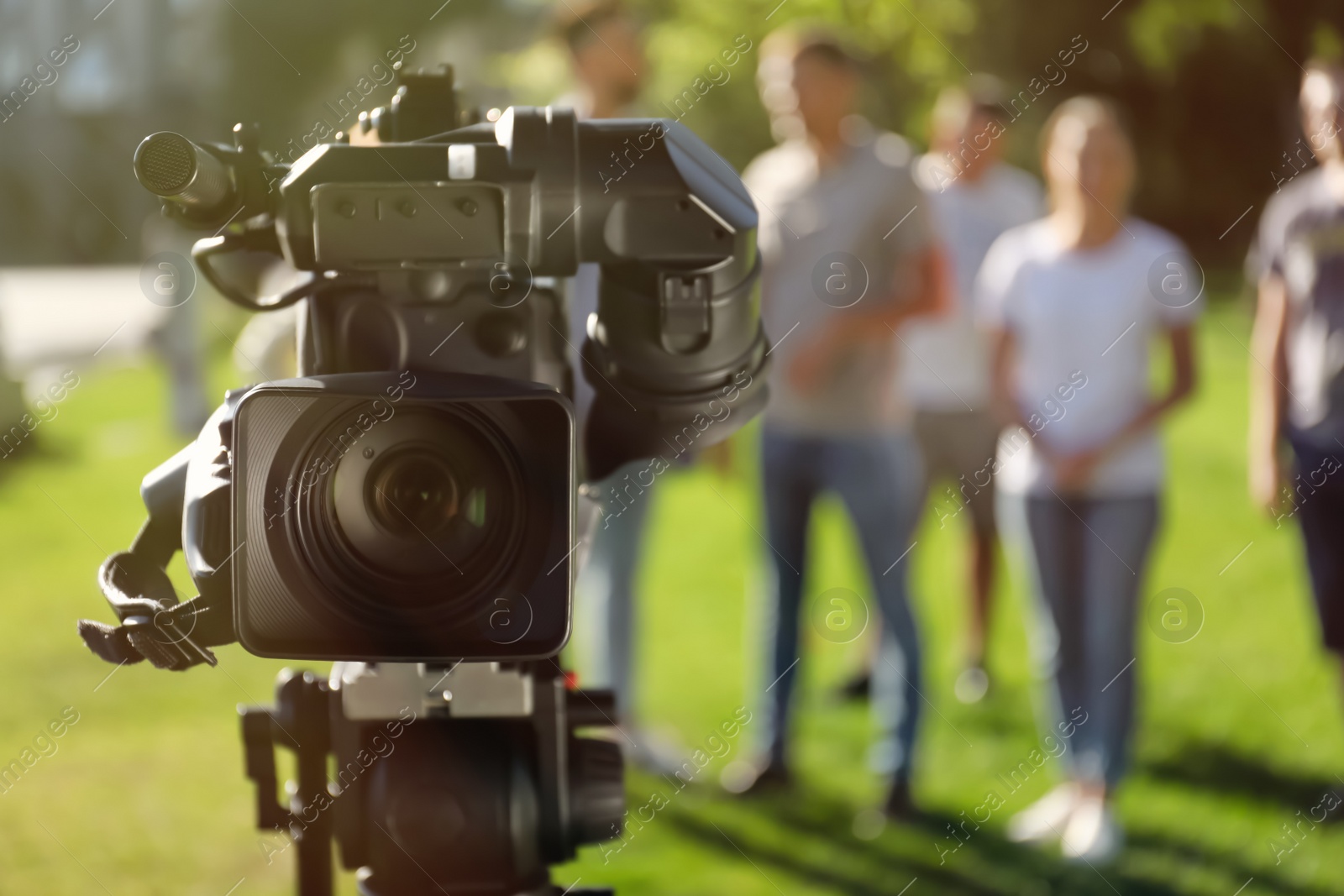 Photo of Professional video camera outdoors and group of people on background