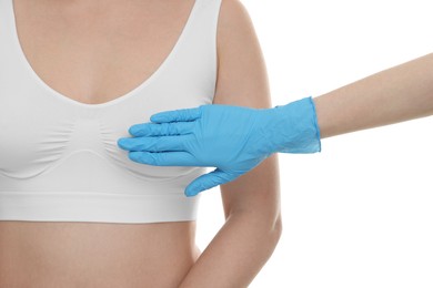 Mammologist checking woman's breast on white background, closeup
