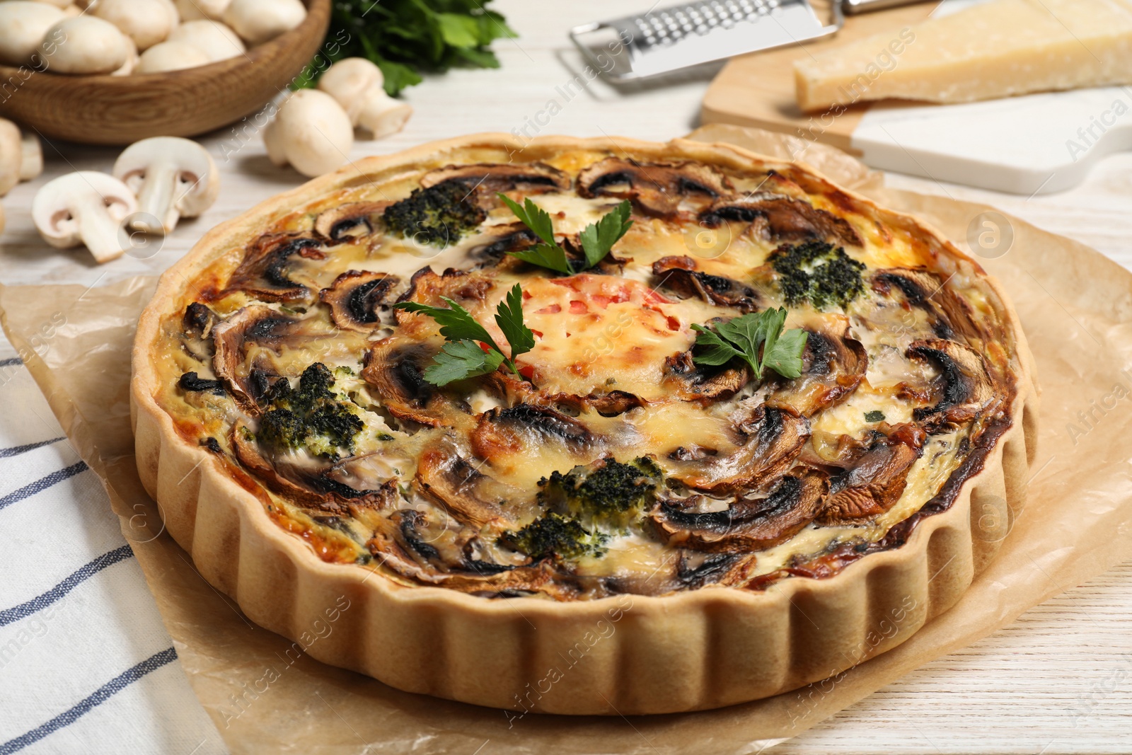 Photo of Delicious quiche with mushrooms and parsley on table, closeup