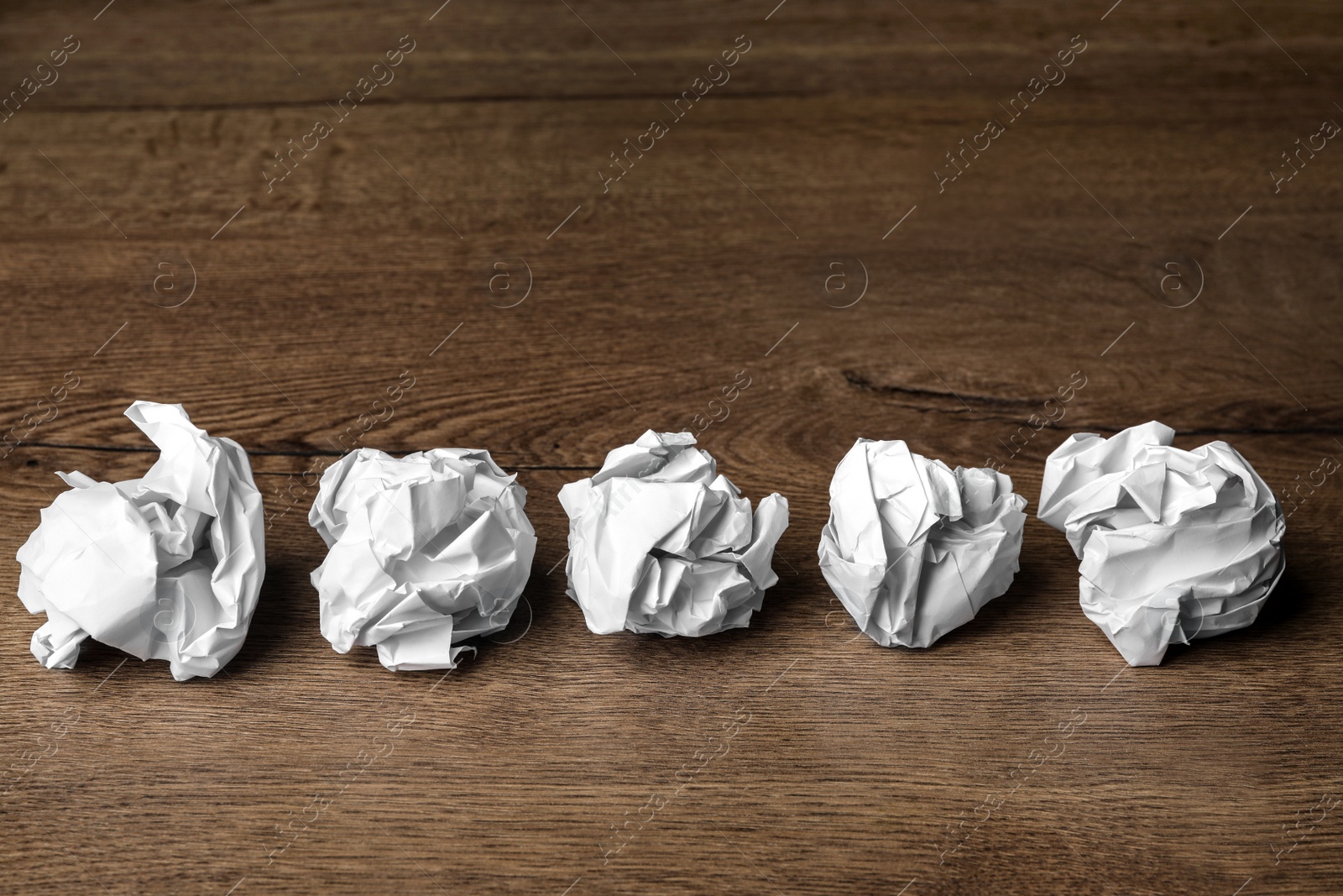 Photo of Balls of crumpled paper on wooden table