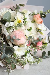 Photo of Bouquet of beautiful flowers on light grey table, closeup