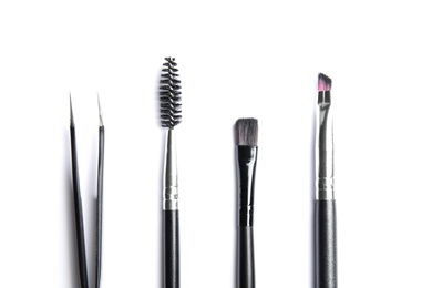 Set of professional eyebrow tools on white background, top view