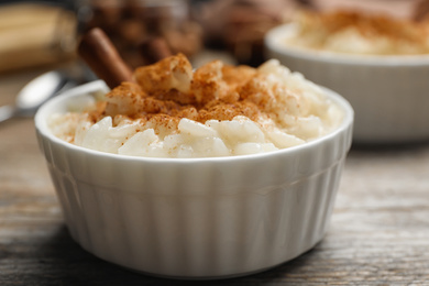 Delicious rice pudding with cinnamon on wooden table, closeup