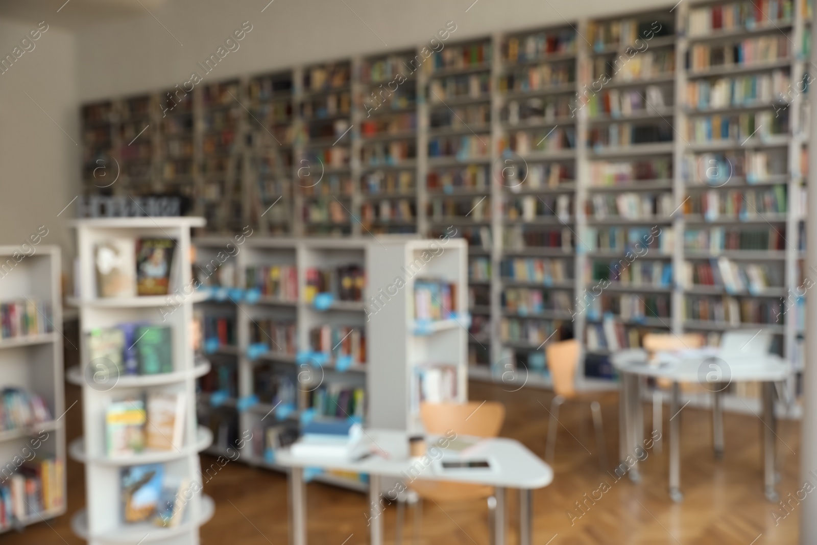 Photo of Blurred view of bookshelves and tables in library