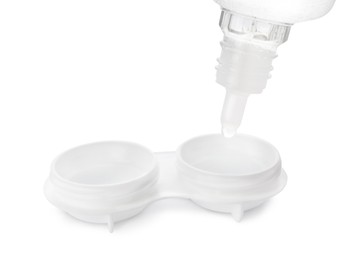 Dripping solution into case with contact lenses on white background