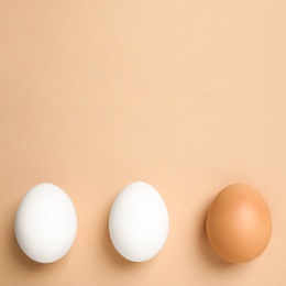 Chicken eggs on beige background, flat lay. Space for text