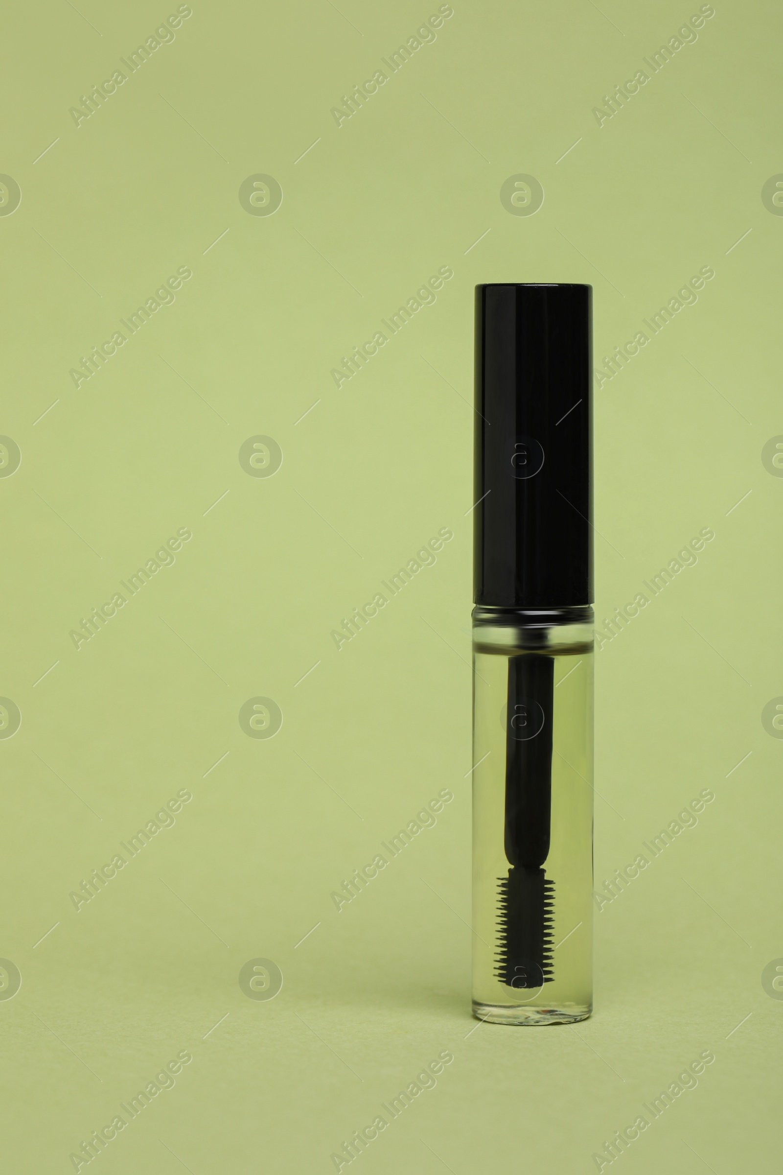 Photo of Tube of eyelash oil on light green background