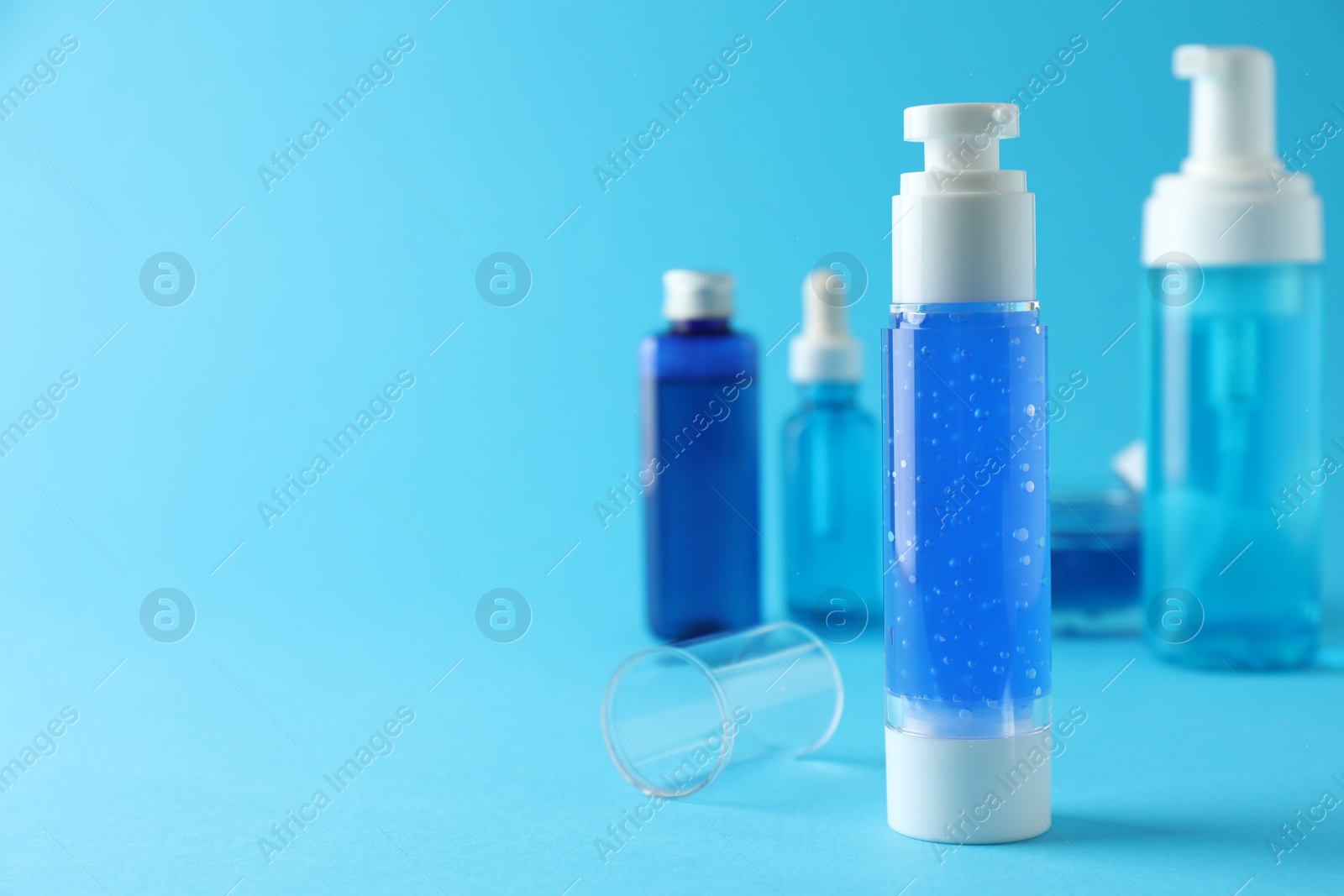 Photo of Different cosmetic products on light blue background. Space for text