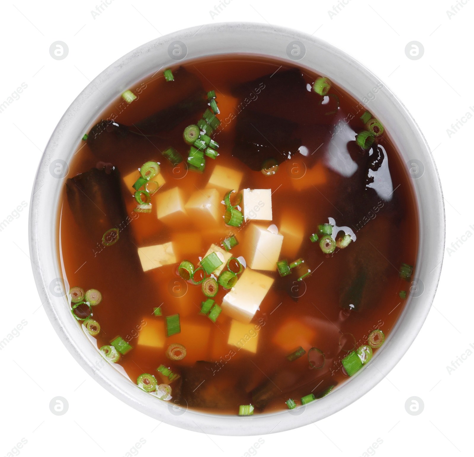 Photo of Bowl of delicious miso soup with tofu isolated on white, top view