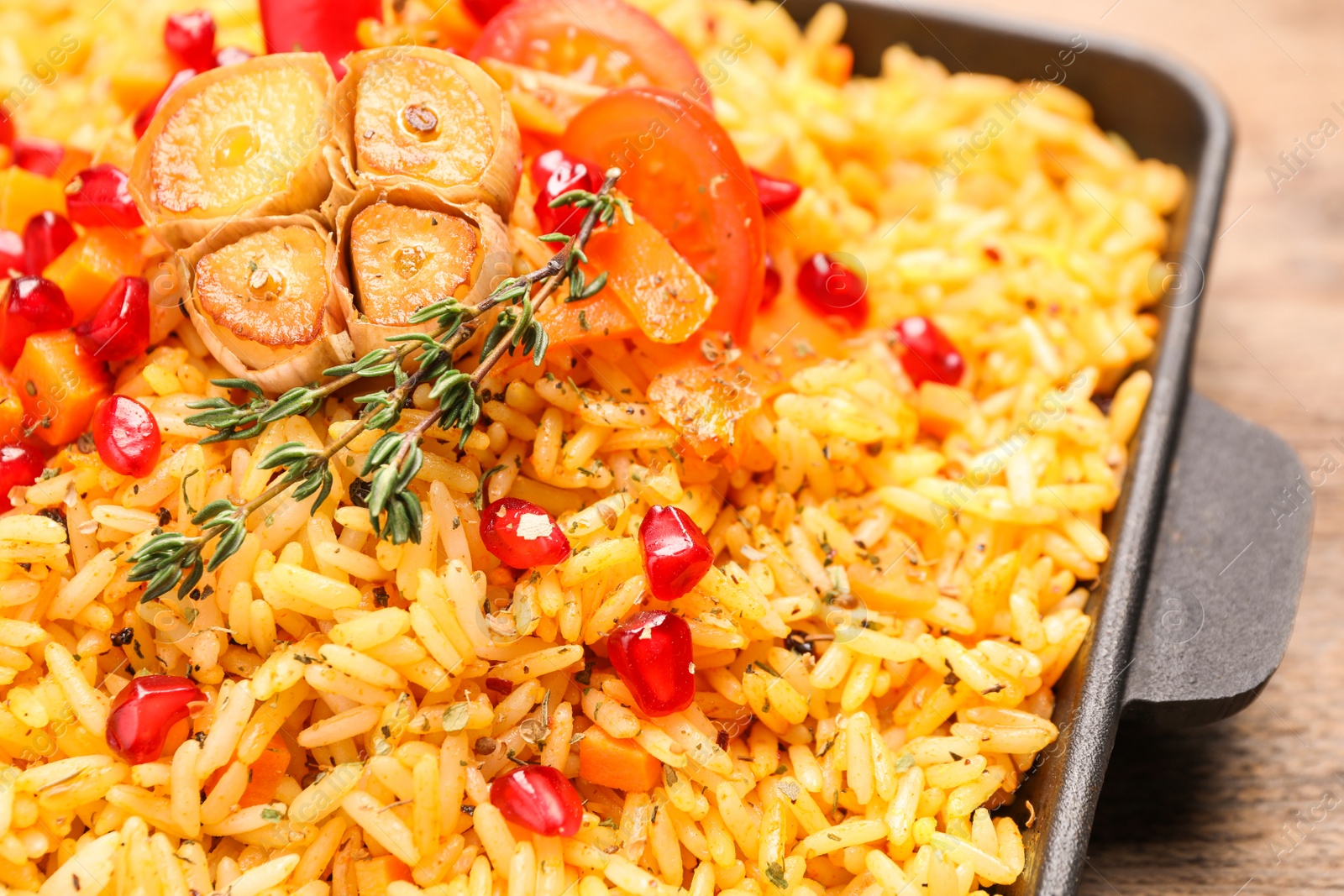 Photo of Tasty rice pilaf with vegetables on wooden table, closeup