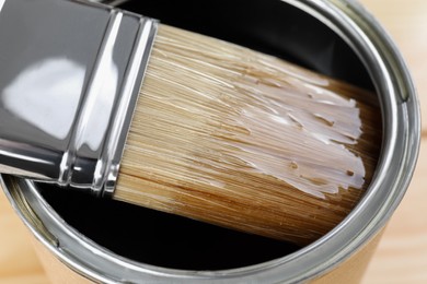 Photo of Dipping brush into can with varnish, closeup