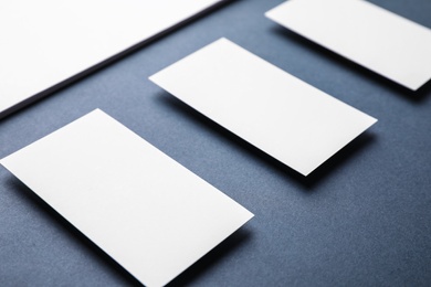 Photo of Blank business cards and paper sheet on dark grey background, closeup. Mock up for design