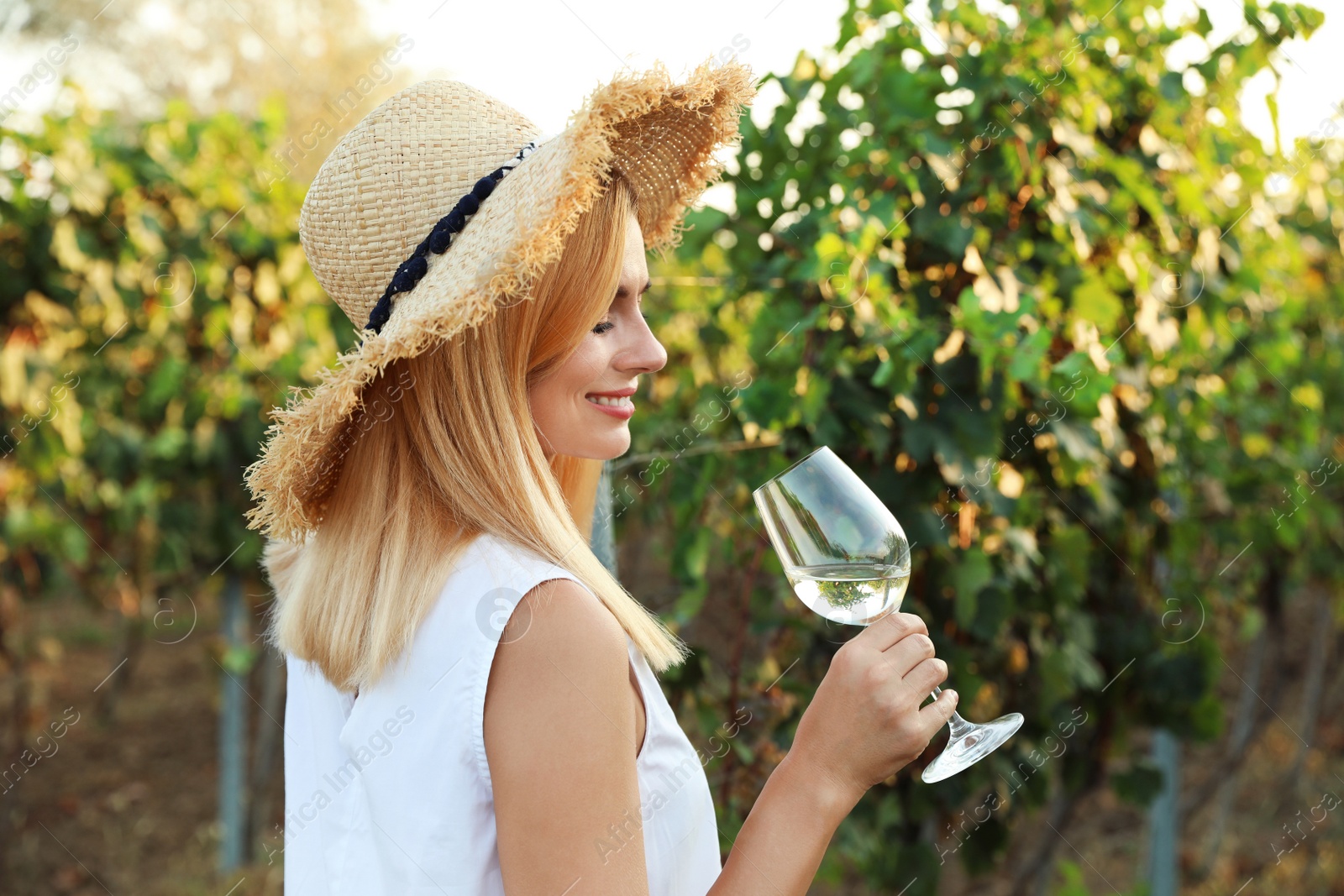 Photo of Young beautiful woman enjoying wine at vineyard