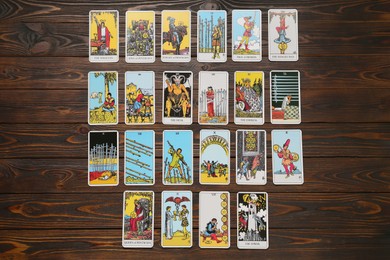 Photo of Tarot cards on wooden table, flat lay