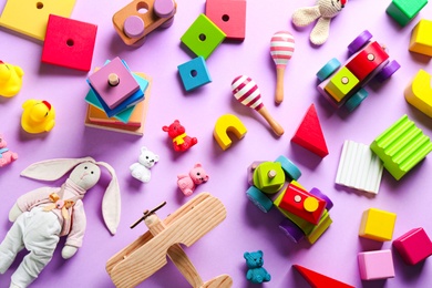 Photo of Different toys on lilac background, flat lay
