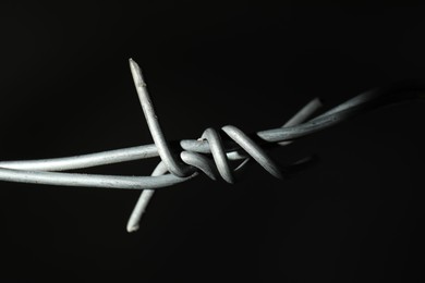 Metal barbed wire on black background, closeup