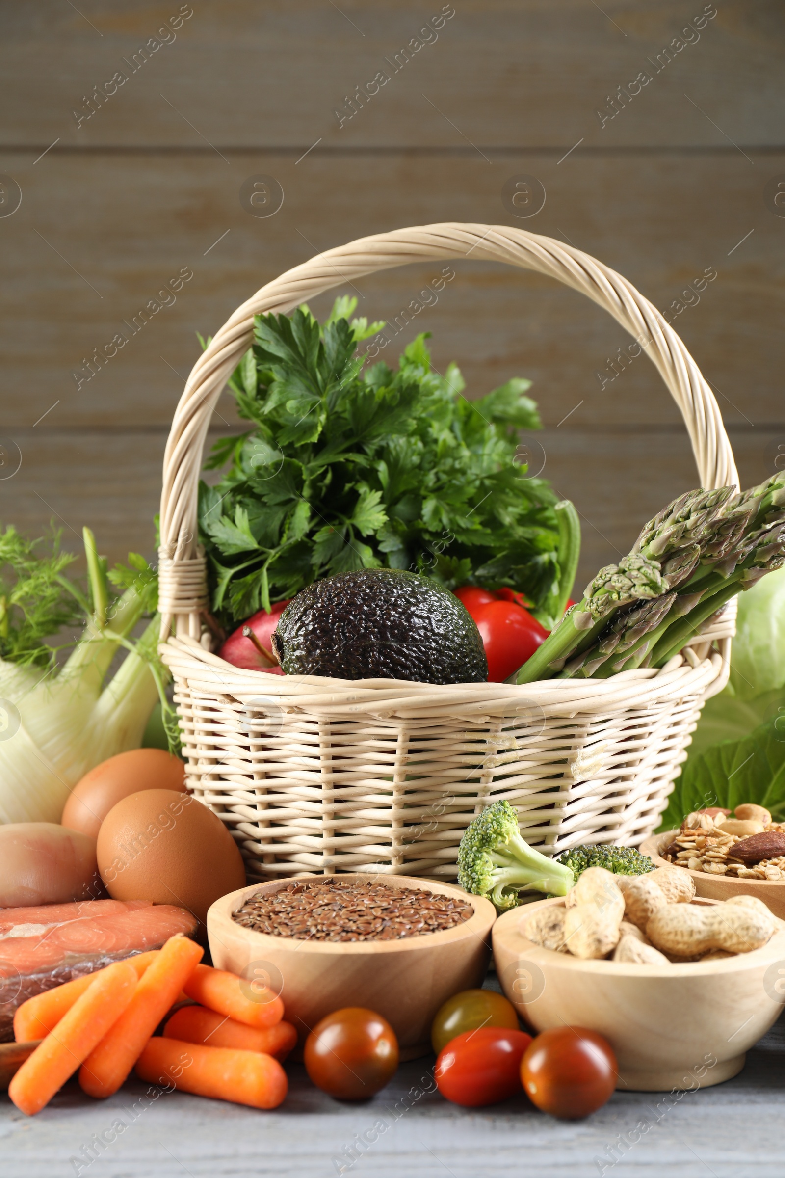 Photo of Healthy food. Basket with different fresh products on grey table