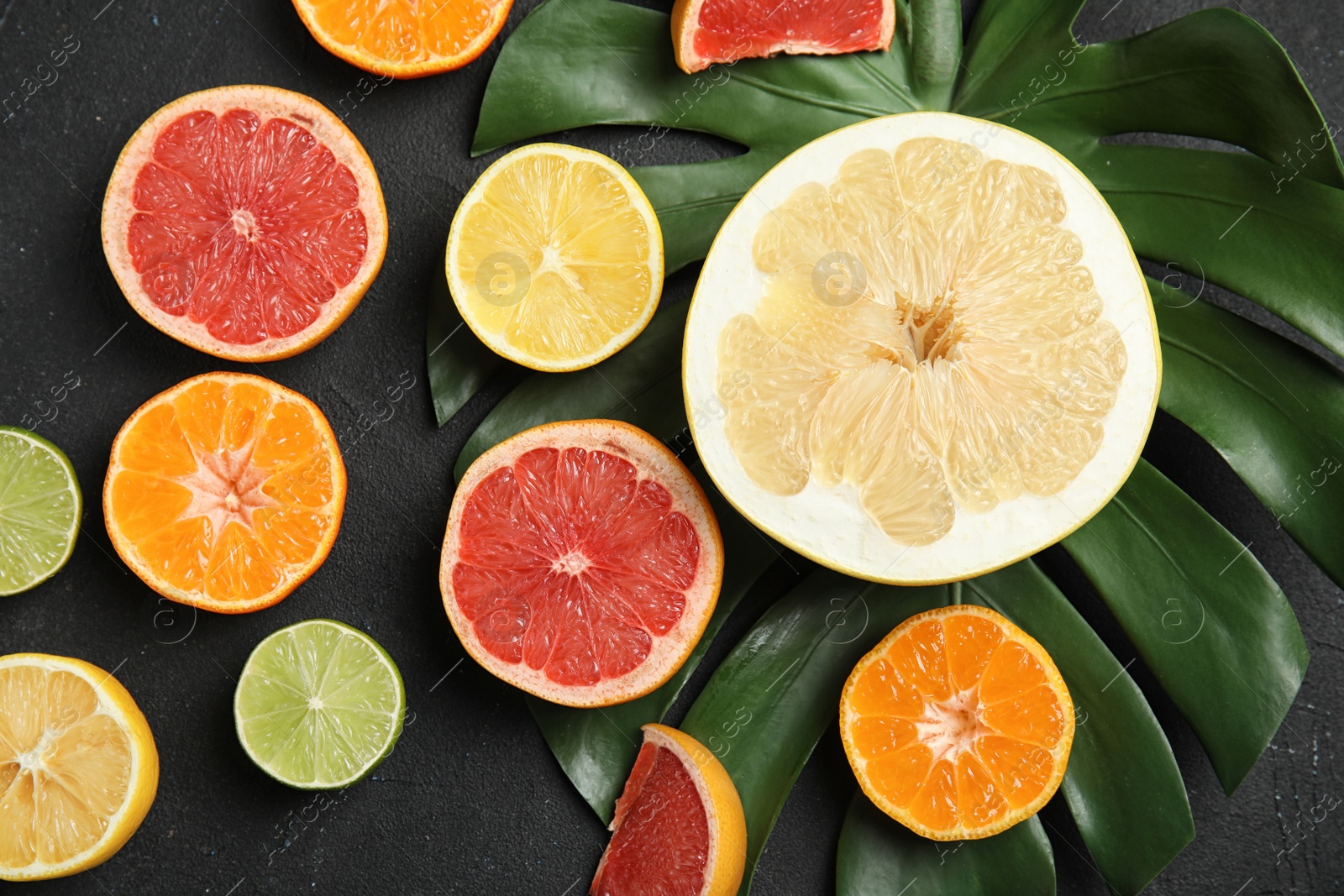 Photo of Different citrus fruits on black background, top view