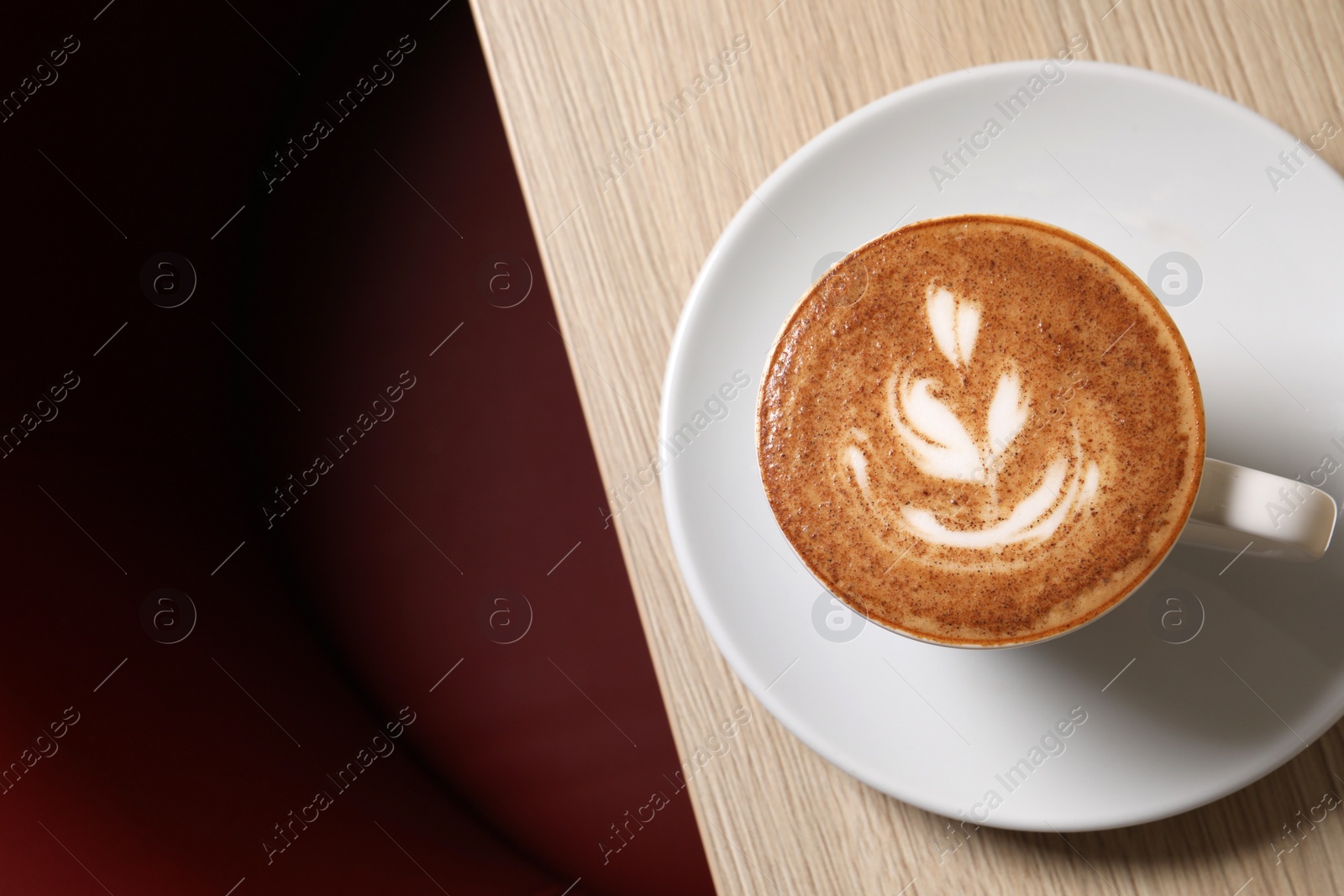 Photo of Cup of aromatic coffee on wooden table in cafe, top view. Space for text