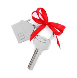 Key with keychain in shape of house and red bow isolated on white, top view