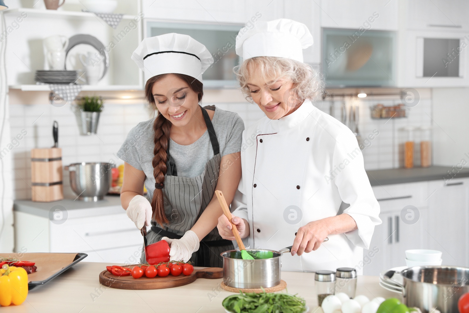 Photo of Professional chef and trainee working together in kitchen