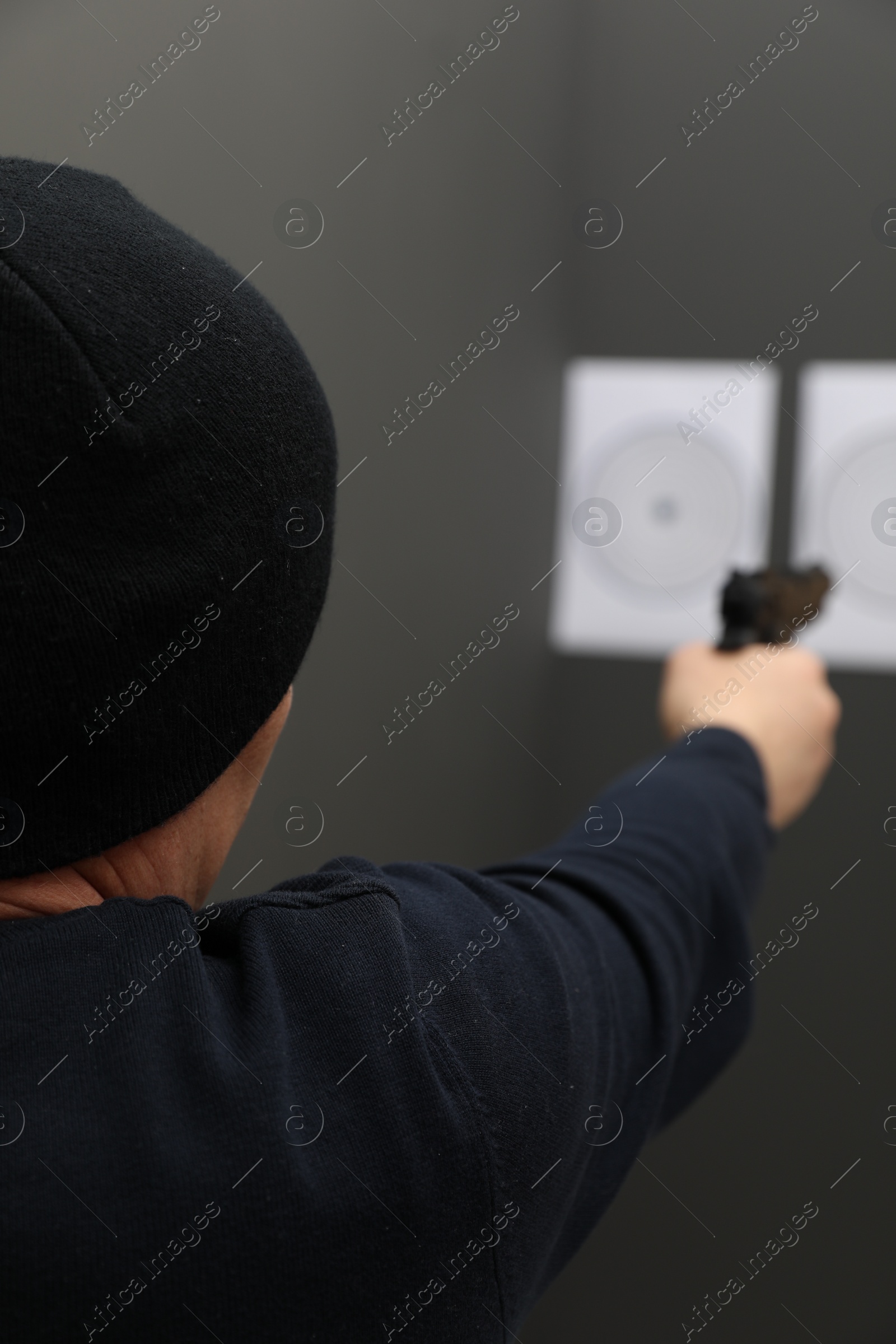 Photo of Man aiming at shooting target indoors, closeup