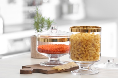 Jars with foodstuff on wooden table in modern kitchen