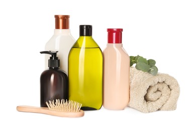 Photo of Different bottles of shampoo, terry towel and wooden brush on white background