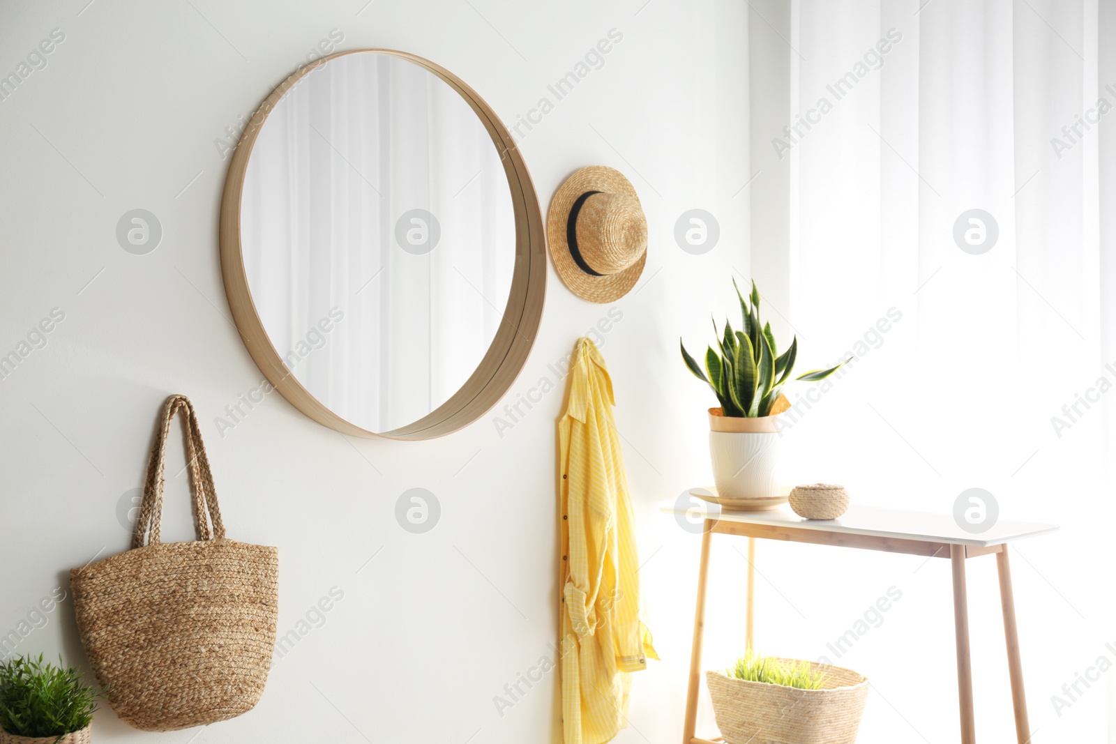 Photo of Round mirror with wooden frame on white wall in light room