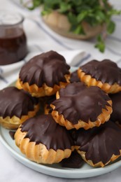 Photo of Delicious profiteroles with chocolate spread on table, closeup