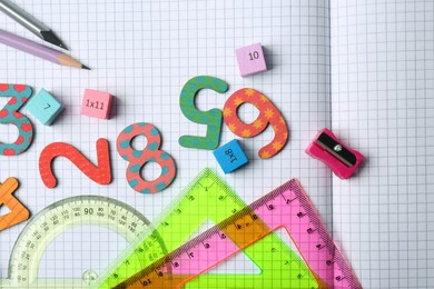 Photo of Flat lay composition with colorful numbers on notebook with grid pages