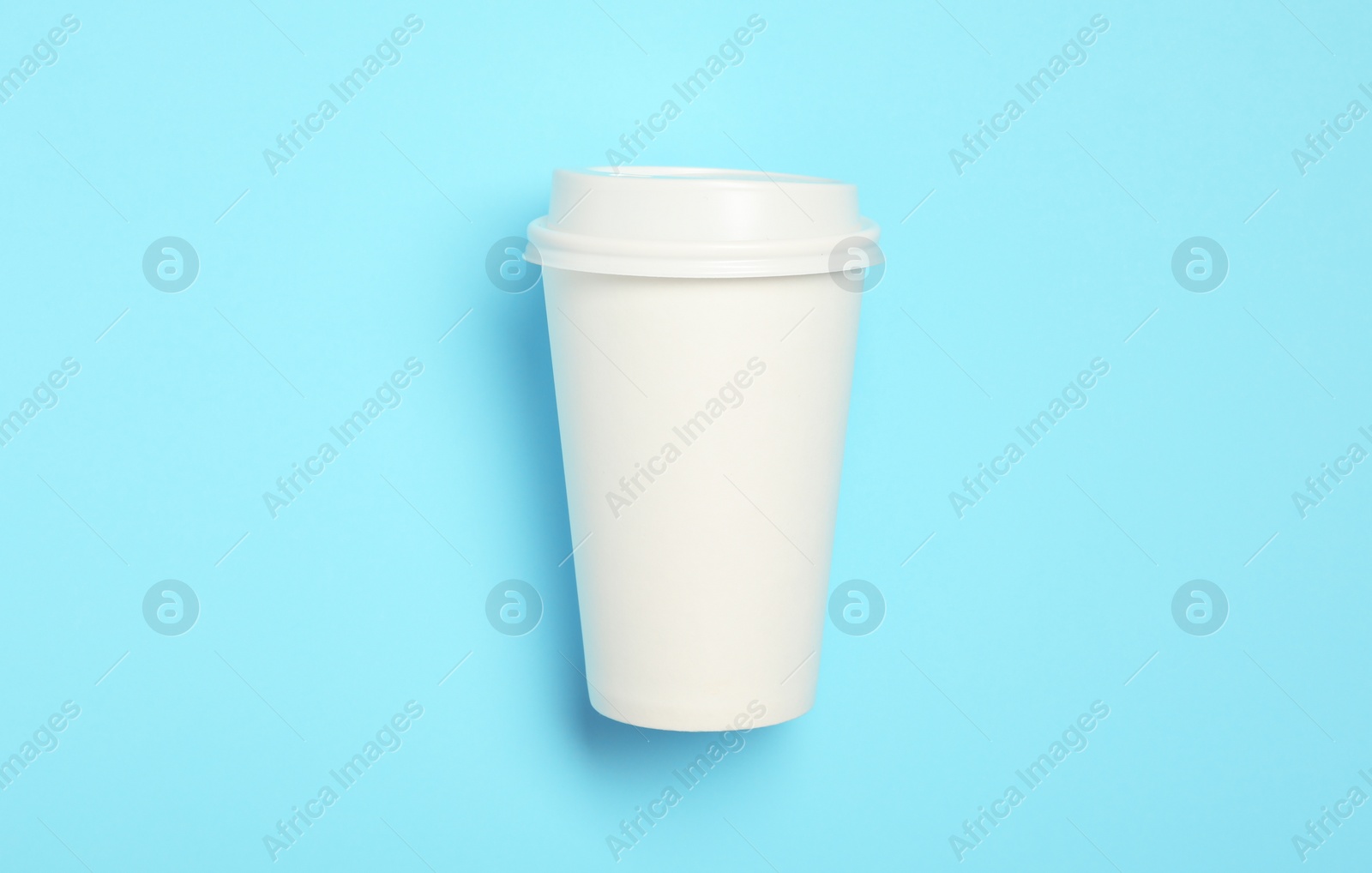 Photo of Takeaway paper coffee cup with on light blue background, top view