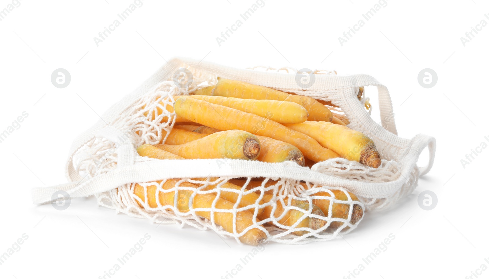 Photo of Raw yellow carrots in mesh bag isolated on white