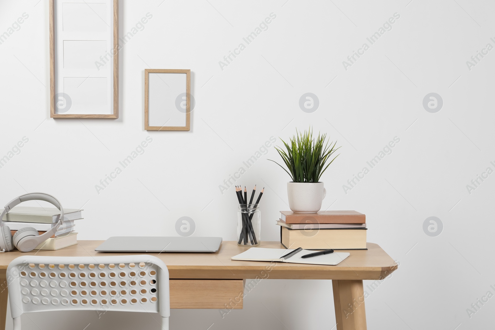 Photo of Cozy workspace with laptop and stationery on wooden desk at home